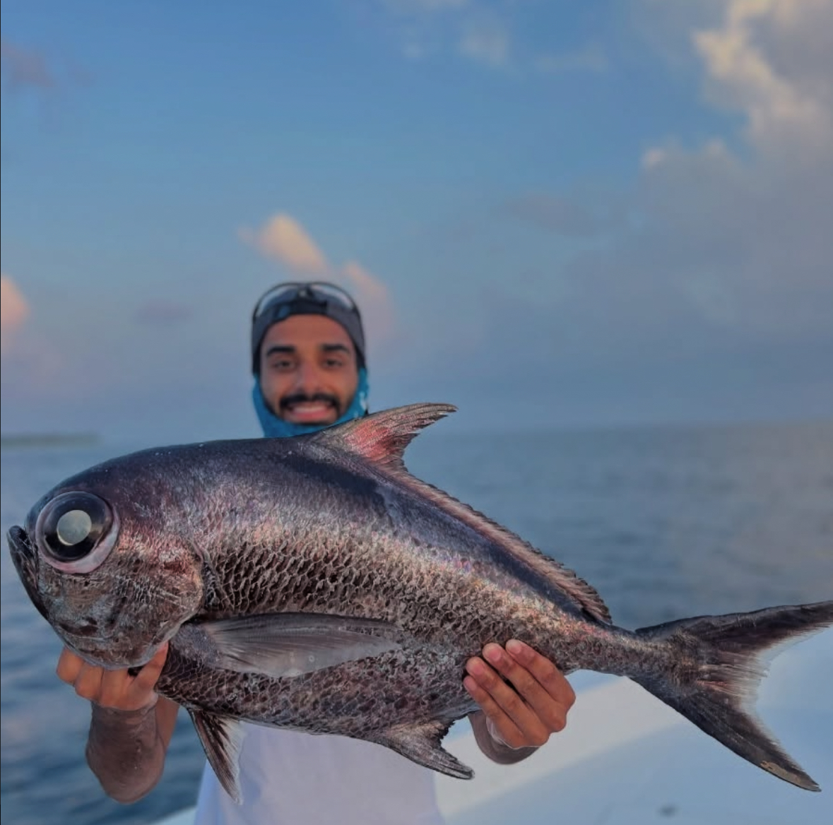 Guest holding a deep sea fish caught jigging in South Ari Atoll