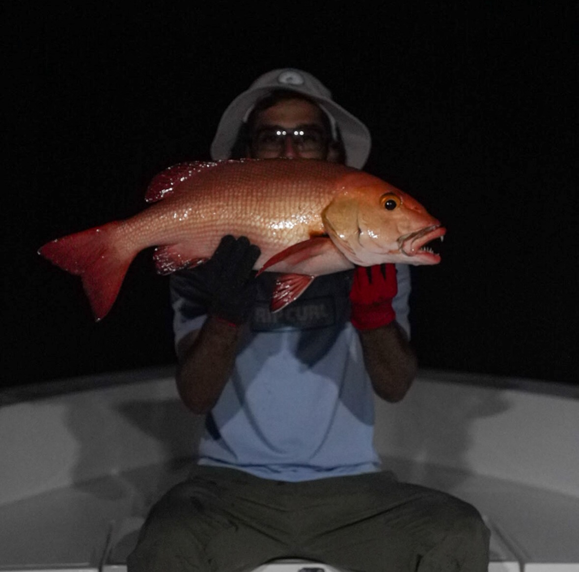 Guest holding a triggerfish caught night fishing with Spear Maldives