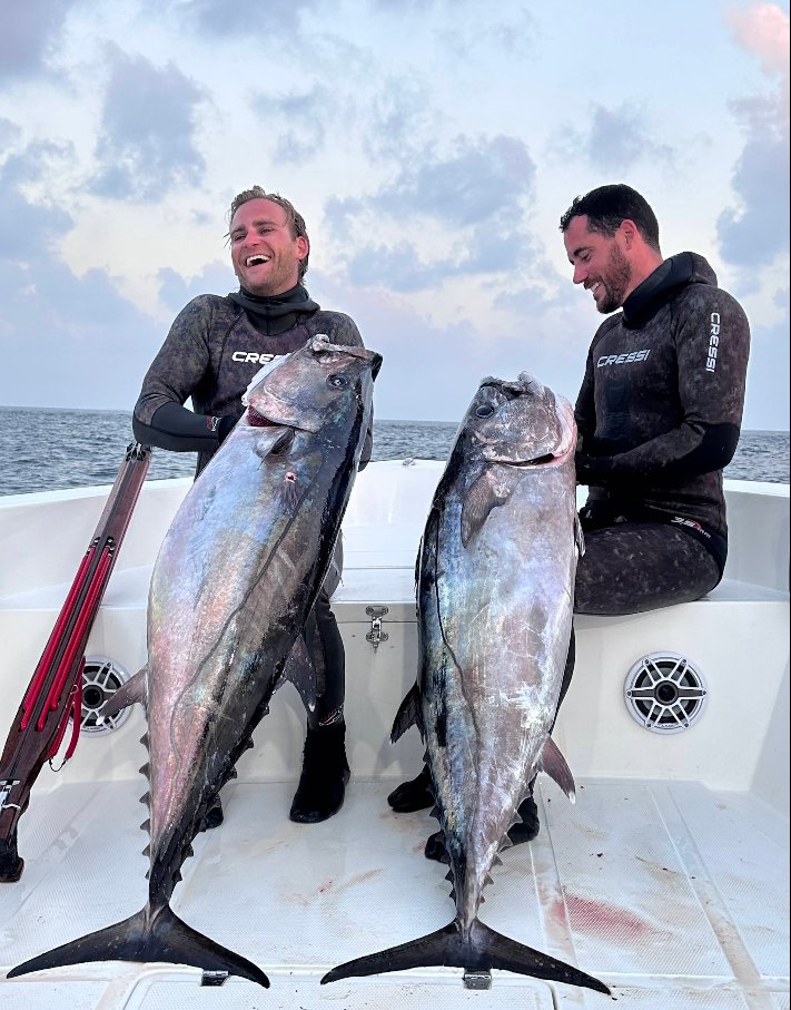 Two spearfishers holding dogtooth tuna caught spearfishing in South Ari Atoll, Maldives