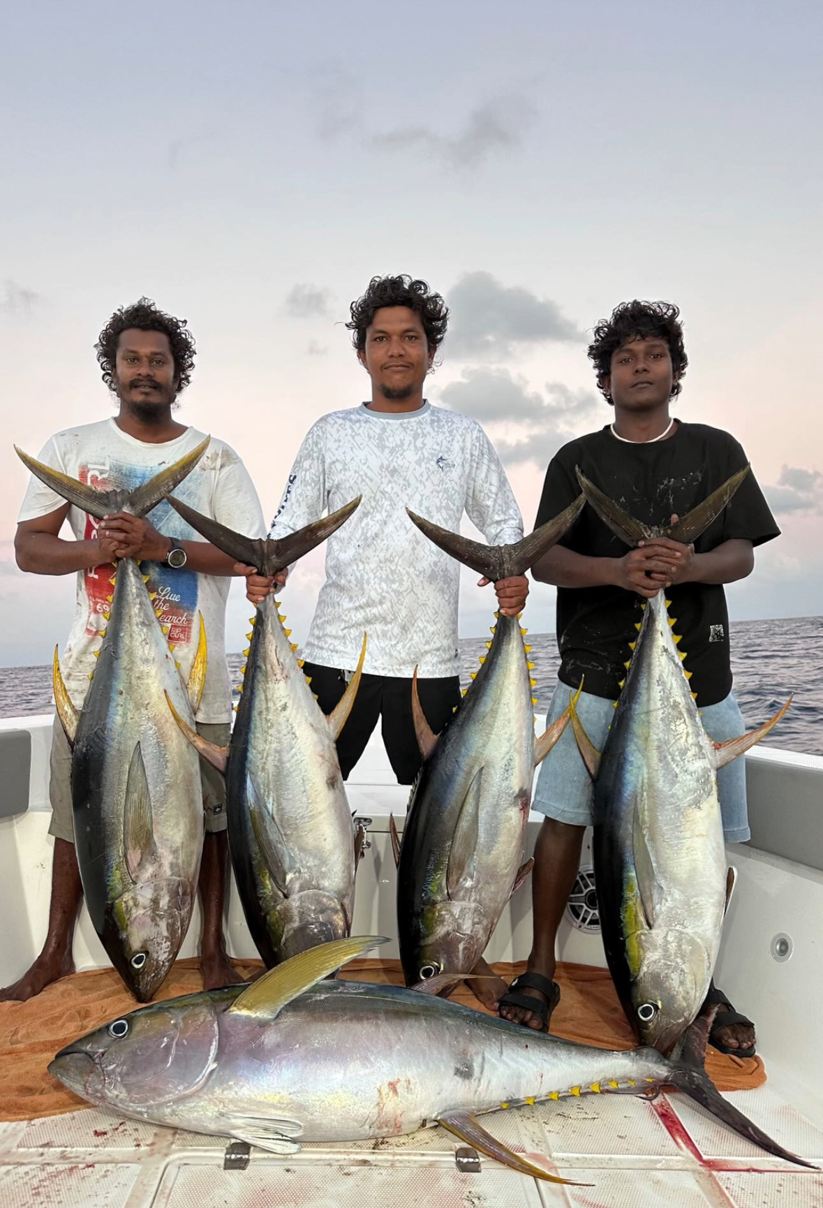 Guest with two yellowfin tuna caught jigging at dusk in South Ari Atoll